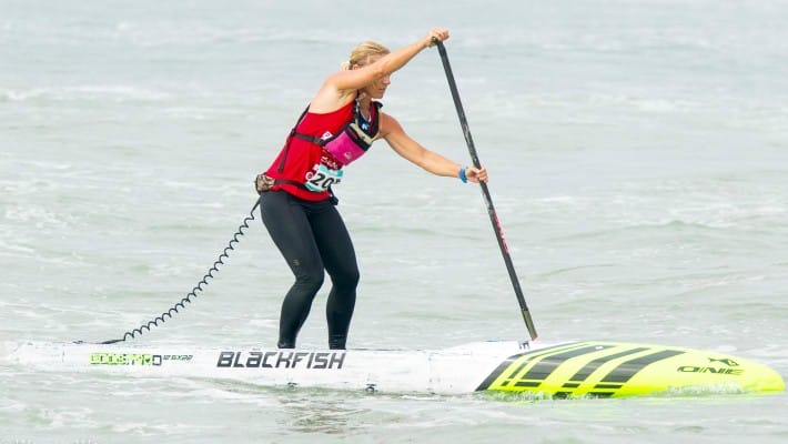Angela Jackson competes in a competitive event aboard one of her own brand ONE Stand Up Paddle's Blackfish model