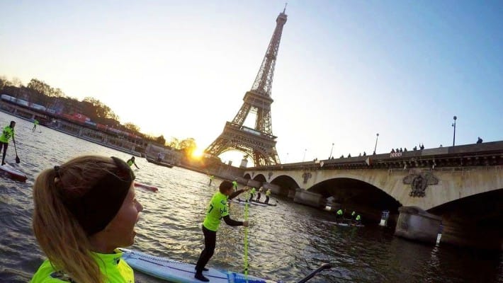 Competitors admire the view as they pass by the Eiffel Tower at the 2016 edition of the Nautic SUP Paris Crossing